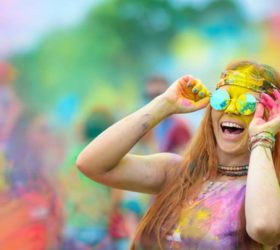 Young cheerful woman at Holi paint party